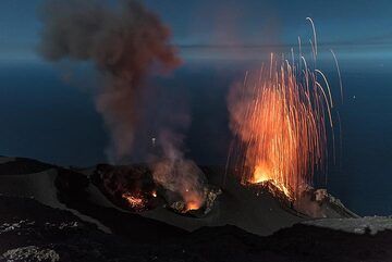 The westernmost (left) vent (S1) has produced an ash-rich eruption; glowing spatter still lies around this vent, which today was not often active (but becomes protagonist a few days later). Seconds later, a dry strombolian eruption occurred from the NE vent (right). (Photo: Tom Pfeiffer)