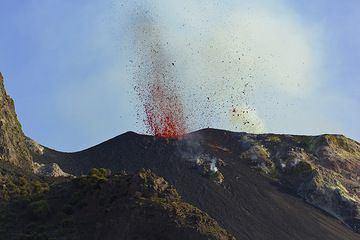 Eruption of the SE crater seen from the 400m viewpoint. The lava is glowing red in full daylight - quite unusual at Stromboli! We're excited to climb further up... (Photo: Tom Pfeiffer)