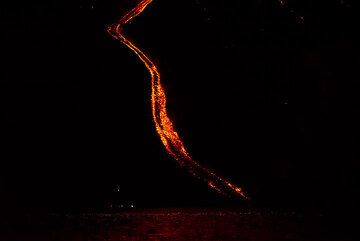At night, the lava flow takes the form of a fiery snake winding down into the sea. (Photo: Tom Pfeiffer)