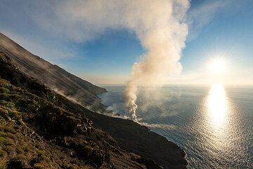 Evening sun and the steam plume from Stromboli's lava flow seen from Punta Labronzo (Photo: Tom Pfeiffer)