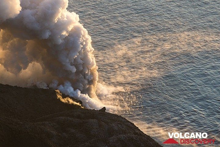 Littoral explosions sending hundreds of small bombs into the air to fall back like hail into the sea. Steaming hot surface water drifts in two directions away from the entry point. (Photo: Tom Pfeiffer)