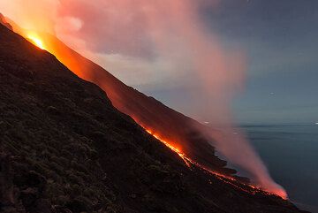 The full moon up, the scene with the lights of the lava, the blue sea and the slope of the volcano and distant islands is simply beautiful. (Photo: Tom Pfeiffer)