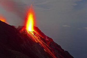 Wide-angle view of the NE vent of Stromboli at night during an eruption. The sea in the background is illuminated by the moon. (Photo: Tom Pfeiffer)