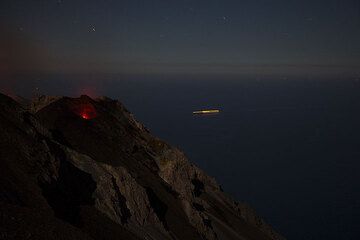 Der NO Krater mit seinen 2 glühenden Schloten bei Nacht. IM Hintergrund die Leuchtspur eines Schiffs auf dem Tyrrhenischen Meer. (Photo: Tom Pfeiffer)