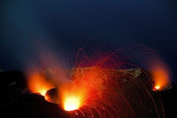 Bright eruption from the central crater and glowing from NE vent (r), and a smaller eruption from the western vent (l). (Photo: Tom Pfeiffer)