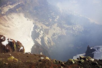 Der Blick in den Krater lässt den Boden nicht erkennen. Er ist heute ruhig, aber bläuliche Wolken aus Schwefeldioxidgas entweichen dem Loch. (c)