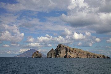 Stromboli is seen in the background behind the small uninhabited islands of Dattilo and Basiluzzo near Panarea. (c)