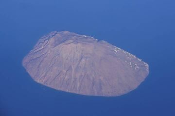 Als das Flugzeug zu sinken beginnt, passieren wir Alicudi, die kleinste der bewohnten Äolischen Inseln. Der alte Krater oben ist gut sichtbar. (Photo: Tom Pfeiffer)