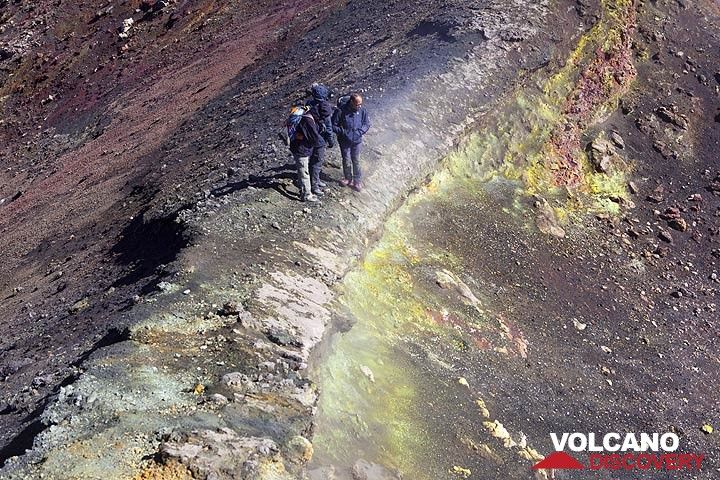 Group on a narrow ledge that separates two vents on Etna volcano, Italy. (Photo: Tom Pfeiffer)