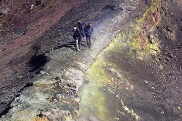 Grupo sobre una estrecha cornisa que separa dos respiraderos en el volcán Etna, Italia. (Photo: Tom Pfeiffer)