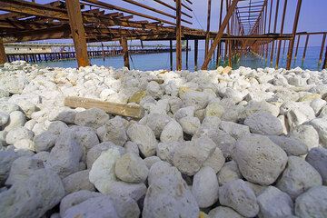 Guijarros de piedra pómez en la playa debajo del viejo y oxidado muelle de la cantera de piedra pómez en Lipari (Photo: Tom Pfeiffer)