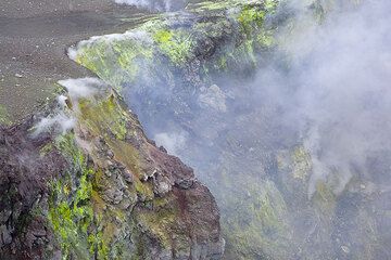 Smoking fumaroles and colorful deposits on the inner crater walls (Photo: Tom Pfeiffer)