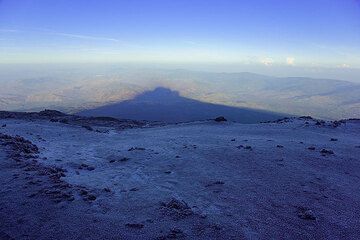 Au moment où nous arrivons du côté nord-ouest des cratères sommitaux, le soleil s'est levé et l'Etna laisse tomber son ombre matinale majestueuse à l'ouest sur la Sicile. (Photo: Tom Pfeiffer)