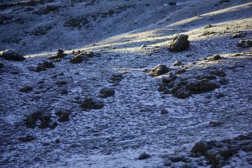 Sunlight and shadow play over the  surfaces of barren lava fields, still covered by thick frost. (Photo: Tom Pfeiffer)