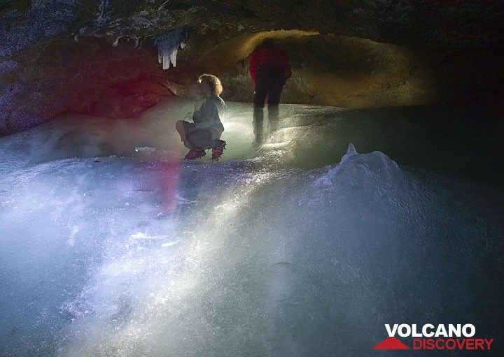 Inès et Rosario dans la grotte, regardant quelques stalactites de glace. Une stalacmite ressemblant à une montagne se trouve au premier plan à droite, causée par l'accumulation de gouttes d'eau ruisselantes et gelées au même endroit. (Photo: Tom Pfeiffer)
