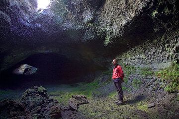 Розарио смотрит на крышу пещеры, где есть световой люк. (Photo: Tom Pfeiffer)