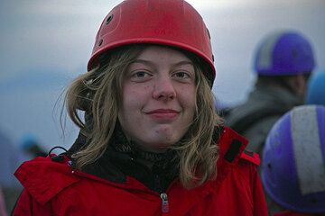 A young teenager happy to be on her first volcano wearing a helmet. (Photo: Tom Pfeiffer)