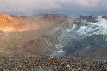 Early sunlight illuminates the reddish pre-1888 ash deposits in the inner western crater rim (Photo: Tom Pfeiffer)