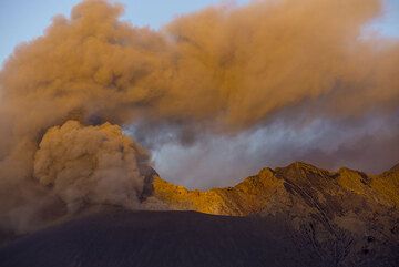 First sunrays illuminate the ash plume from Showa crater. (Photo: Tom Pfeiffer)