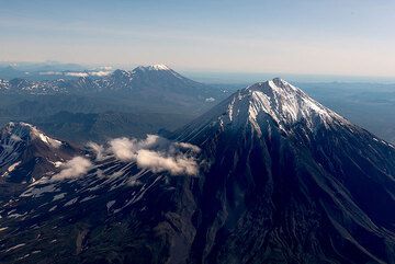 2 Sep 2017: The longest domestic flight in the world, Moscow-Petropavlowsk (7-8 hours), is almost over as the plane is descending in brilliant weather to the airport: we pass south of the majestic stratovolcano of Koryaksky looming over the Avachinsky Bay where the capital is located. In the background, the Zhupanowsky volcano complex, and (far left corner), Karymsky volcano with a small plume are visible as well. (Photo: Tom Pfeiffer)