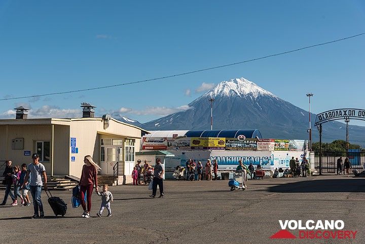 Arrived! People leave the small luggage delivery room of the airport and are greeted by unusually good weather with snow-capped Koryaksky volcano behind. (Photo: Tom Pfeiffer)