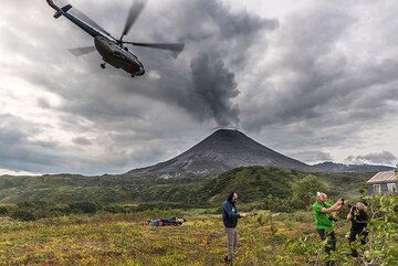 The helicopter leaves. The cozy volcanologists' hut where we will spend the next days is visible in the right. (Photo: Tom Pfeiffer)