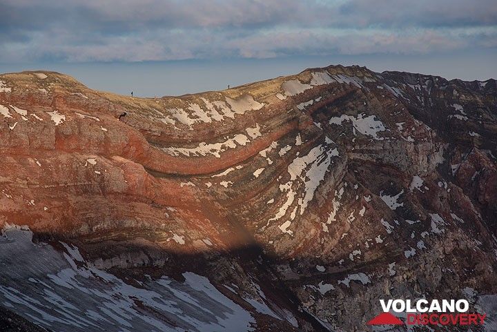 Last sunlight paints the inner crater walls with red light. Note the silhouettes of some hikers for scale. (Photo: Tom Pfeiffer)