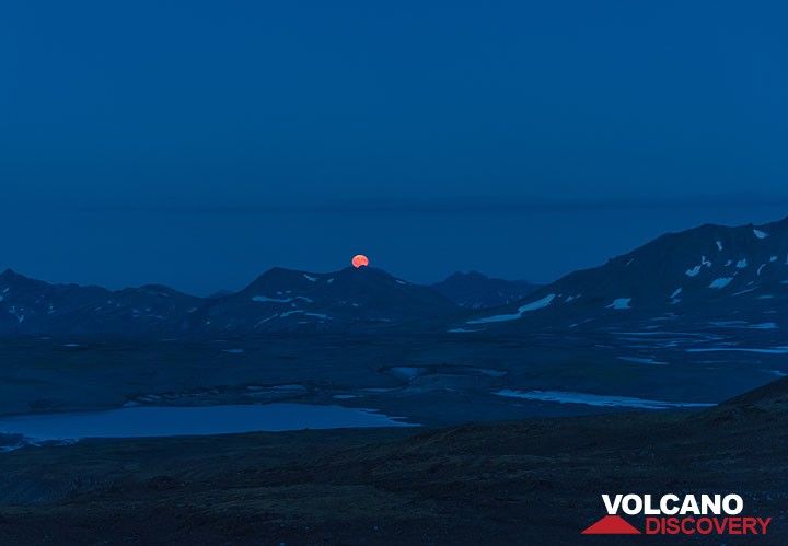 A brilliant orange moonrise over the eastern horizon's mountain peaks. (Photo: Tom Pfeiffer)