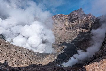 Weitwinkelaufnahme in den SW-Krater mit der stärksten Fumarole, die eine dichte Dampfwolke ausstößt. (Photo: Tom Pfeiffer)