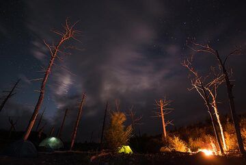 Lagerfeuer in der Nacht, während man auf klaren Himmel wartet. (Photo: Tom Pfeiffer)