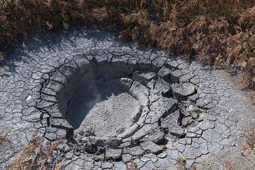 Circular mud pond about 3 meters across. (Photo: Tom Pfeiffer)