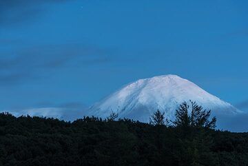 The Tolbachik volcano massif seen in the evening blue hour from our campsite. To the left, the active Plosky (flat) Tolbachik (3,085 m), a very active shield volcano, and to the right, the taller Ostry (sharp) Tolbachik (3,682 m), a now extinct stratovolcano. (Photo: Tom Pfeiffer)