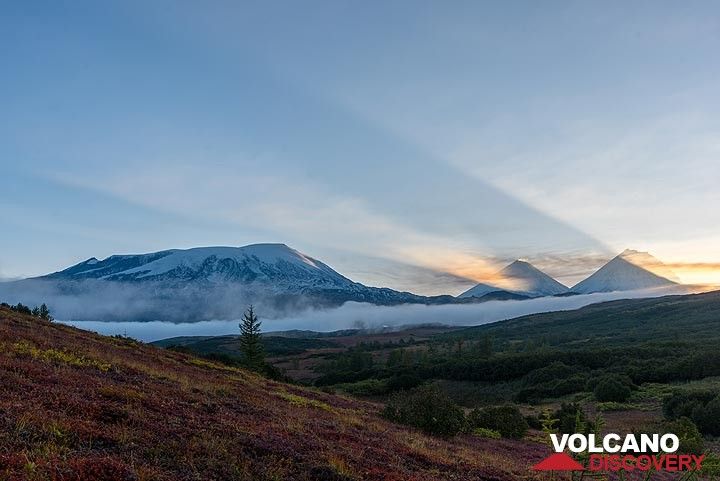 Sunrise view towards Ushkovsky volcano (l) and the peaks of Klyuchevskoy and Kamen volcanoes (r). (Photo: Tom Pfeiffer)