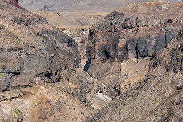 Massive lava flow and tephra layers are exposed in the vertical canyon walls. (Photo: Tom Pfeiffer)