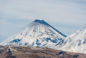 Klyuchevskoy volcano, weakly active, is emitting white steam plumes, and its summit area at approx. 4835 m a.s.l. is either covered with some ash and/or snow has melted by warm emissions. (Photo: Tom Pfeiffer)