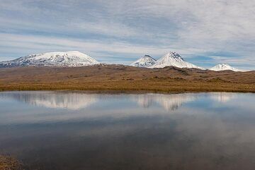 A small lake on the top of the plateau provides opportunities to play with mirror images of the snow-clad volcanoes. (Photo: Tom Pfeiffer)