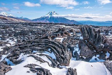 Ropy pahoehoe lava and Udina volcano (Photo: Tom Pfeiffer)