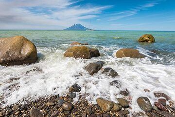 Brechende Wellen, Alaid und unsere Yacht im Hintergrund. (Photo: Tom Pfeiffer)