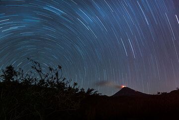 Weitwinkel-Langzeitbelichtung mit Polaris-Rotationszentrum links und Colima mit der leuchtenden Kuppel rechts. (Photo: Tom Pfeiffer)