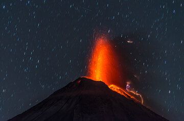 Lava-rich eruption early on 7 January with stars and a satellite trace. (Photo: Tom Pfeiffer)