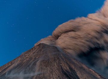 A few seconds exposure time blurs the ash plume drifting away from the crater to the SE. (Photo: Tom Pfeiffer)