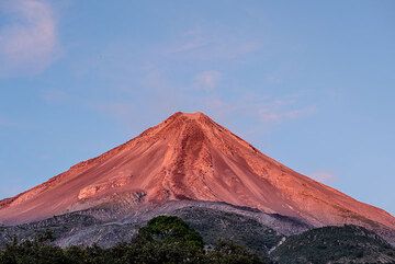 La luz del sol en 27 Feb pinta majestuoso cono simétrico de Colima rojizo. (Photo: Tom Pfeiffer)
