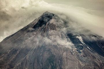 In the afternoon of 12 July, pyroclastic flows cease. Probably at the same time, a lava flow starts to slowly descend on the southern flank (right). This image shows the lava flow 2 days later, visible as a dark tongue on the upper slope. A now inactive lava lobe forms a prominent dark patch on the upper SW flank (left). It had been emplaced during the previous week or weekend.  (Photo: Tom Pfeiffer)