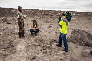 Antonio, whose land was invaded by the flow, explains journalists that below the surface, the deposit is still hot enough to burn wood. (Photo: Tom Pfeiffer)