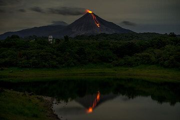 The volcano and its active lava flow mirrored in the lake. (Photo: Tom Pfeiffer)