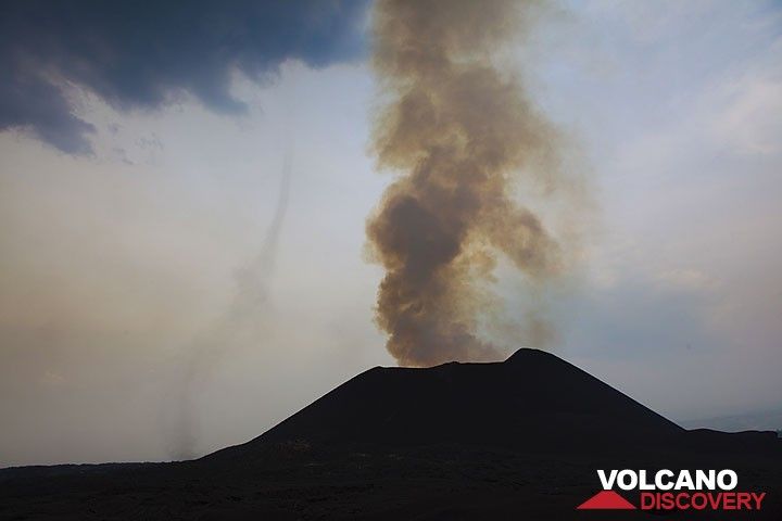 The active eastern cone of Kimanura. Hot rising air near the area where the lava tube begins at the base of the cone forms a small tornado. (Photo: Tom Pfeiffer)