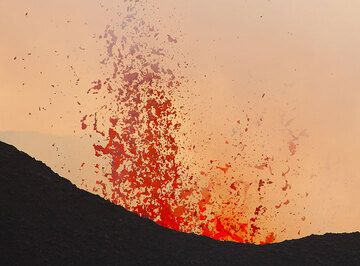 During phases of stronger degassing from the lava-filled vent inside the crater, lava bursts reach tens of meters above the crater rim. (Photo: Tom Pfeiffer)