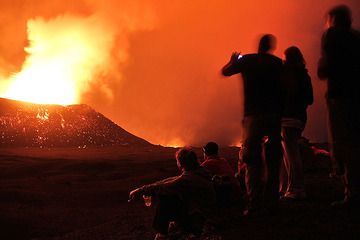 Mostly employees of UN and NGOs from all over the world but all working in Goma (I was the only tourist) watch the night show. Note that so much gas was expelled from the crater and the strong glow indicated lava lake inside the crater that night photography was very difficult due to overexposure with flying rocks being mostly lost within the glowing plume (night video however is excellent). (Photo: Paul Hloben)