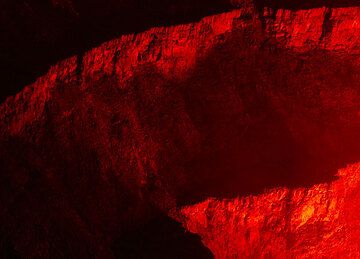 Crater walls of Nyiragongo with the first terrace, illuminated by the lava lake at night. (Photo: Tom Pfeiffer)