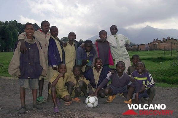 Group photo at the football field, Nyiragongo volcano looms in the background. (Photo: Tom Pfeiffer)